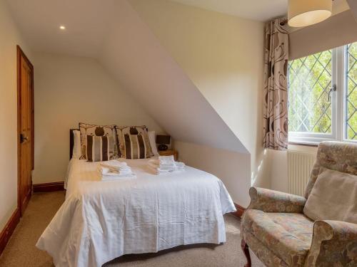 布兰登Riverside Cottage-uk41439的卧室配有床、椅子和窗户。