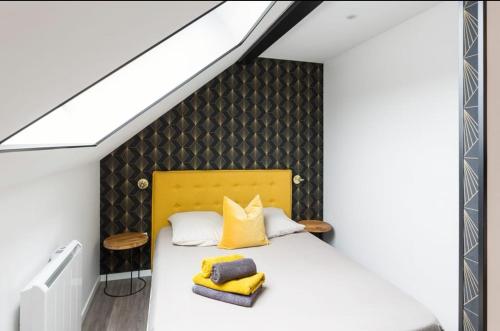 兰斯Bienvenue à Reims type studio charmant et lumineux 2eme étage的一间卧室配有一张黄色床头板的床