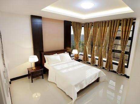 大雅台tagaytay transient ph的卧室配有白色的床和窗户。
