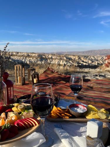 乌奇希萨尔Soleado Cappadocia Hotel的一张桌子,上面放着两杯葡萄酒和食物