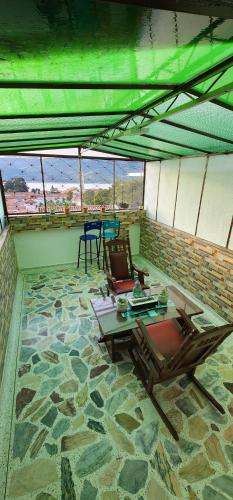 瓜塔维塔HOSPEDAJE DE GUATAVITA的石地板上配有桌椅的房间