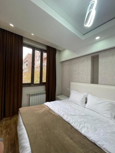 埃里温Apartment in Tumanyan street的一间卧室设有一张大床和一个窗户。
