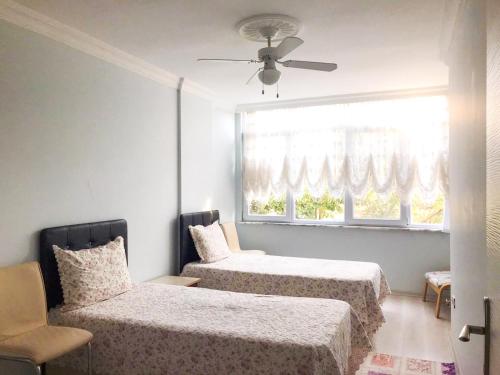 埃德雷米特Altınkum Sahil'de bahçeli nezih yazlık的一间卧室设有两张床和窗户。