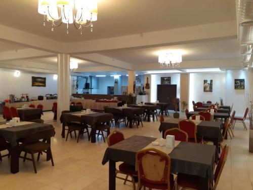 埃尔比勒Hotel Sinaia Palace的一间带桌椅的餐厅和一间用餐室