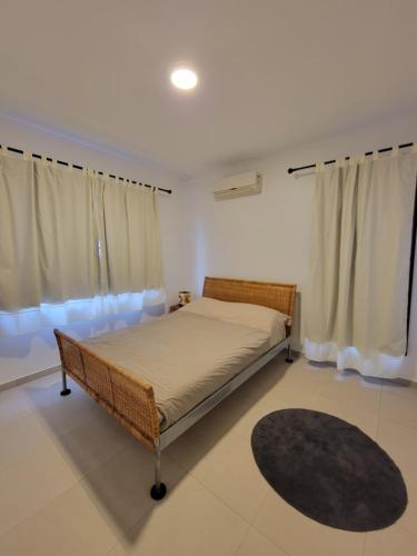 帕拉马里博Modern - Wan Pipel with Terrace的一间卧室配有床、窗帘和地毯