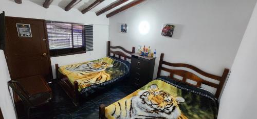 瓜塔维塔HOSPEDAJE DE GUATAVITA的两张带老虎的床。