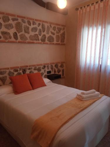 托莱多SEÑORÍO DE ORGAZ II的卧室配有带橙色枕头的大型白色床