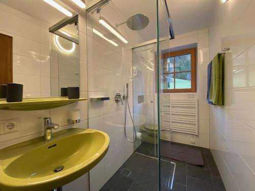 瓦格赖恩Oberleiten Apartments的浴室配有黄色水槽和淋浴。