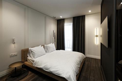 布克维Cristal Garden Chalet的一间卧室配有一张带白色床单的床和一扇窗户。