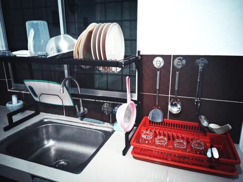 山打根VIRTA Guesthouse的厨房配有水槽和红色碗碟干燥架