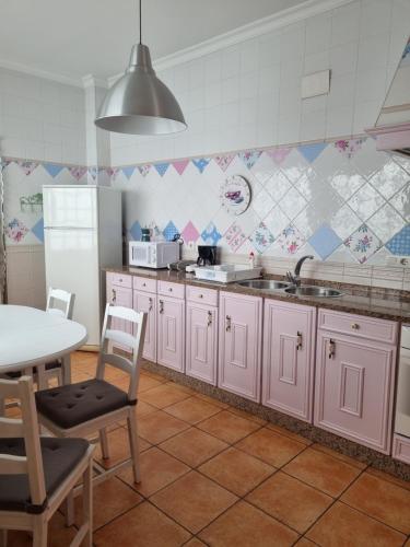 莫拉尔岛Mar的厨房配有粉红色的橱柜和桌子