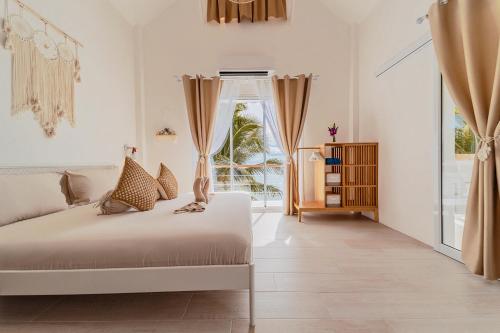 通萨拉Sunset Lover Beach Residence的白色的卧室设有床和窗户