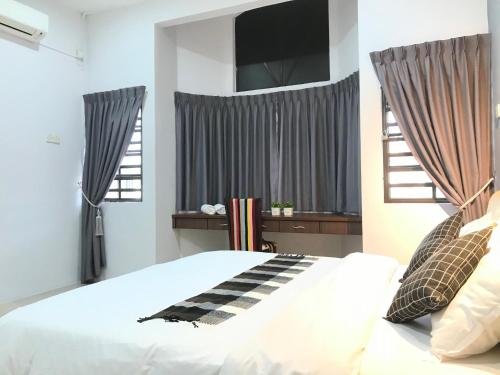 怡保Ipoh Homestay Cozy and Comfortable 4R3B 13pax Indoor Car Parking SY12的卧室配有一张带 ⁇ 面毯的白色床