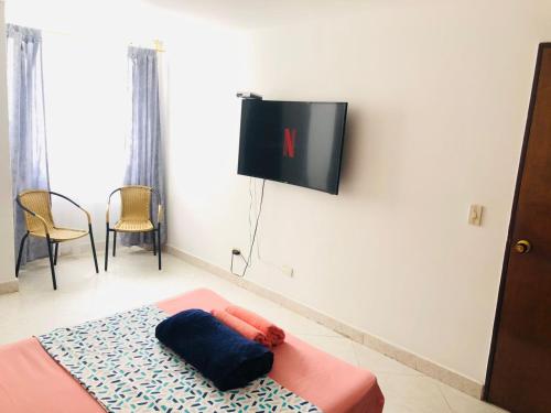麦德林M&N Alojamiento es una habitación en un apto的墙上配有平面电视的房间