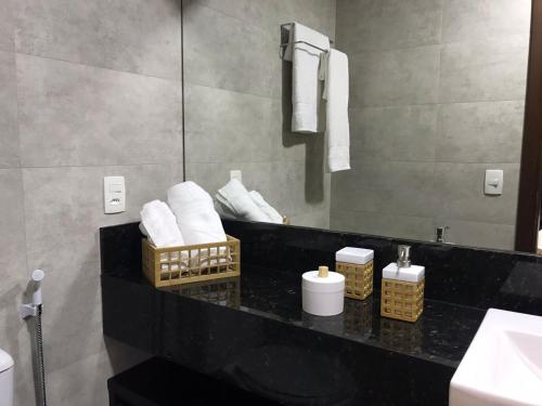 尼泰罗伊Maravilhoso Loft vista mar OCEANVIEW的浴室设有黑色柜台、毛巾和镜子