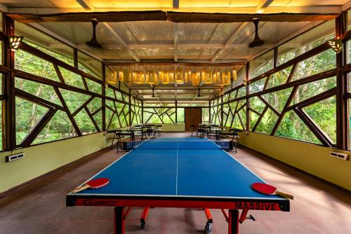 坎哈Kanha Jungle Camp的大窗户的大客房内的乒乓球桌
