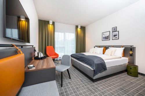 梅彭VIA PLAZA Hotel Meppen的配有一张床和一张书桌的酒店客房