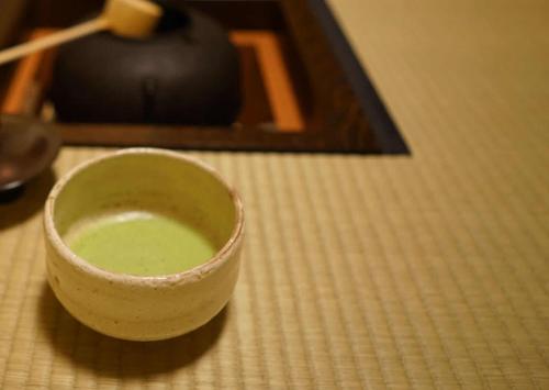 京都东篱日式旅馆的坐在桌子上的一个绿杯