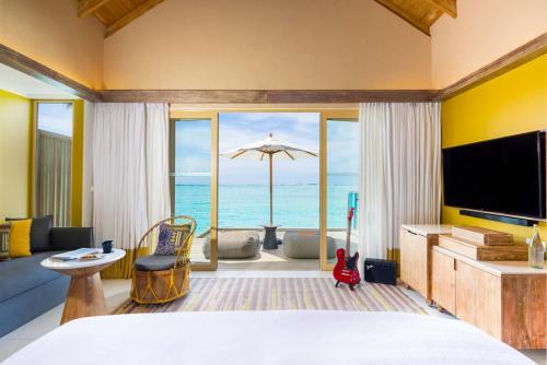 南马累环礁Hard Rock Hotel Maldives的一间卧室配有一张床,享有海景