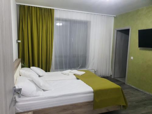 ApateuVilă primitoare în Cihei ideală pentru grupuri.的一间卧室配有两张白色的床和绿帘