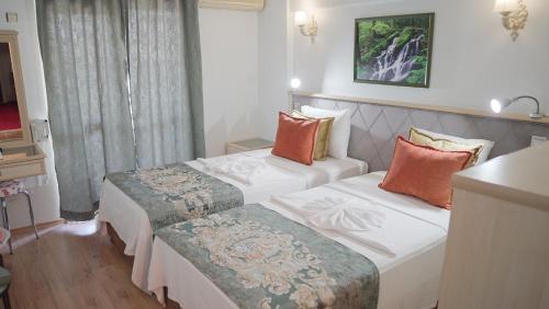 迪迪姆Panormos Hotel的一间酒店客房,房间内设有两张床