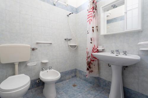 托雷莫泽Appartamento fronte mare e spiaggia的白色的浴室设有卫生间和水槽。