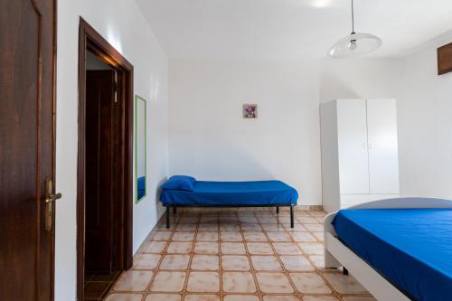 托雷莫泽Appartamento fronte spiaggia e vista mare climatizzato的一间设有蓝色床和门的房间