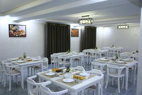 努库斯CITIZEN HOTEL的用餐室配有白色的桌子和白色的椅子