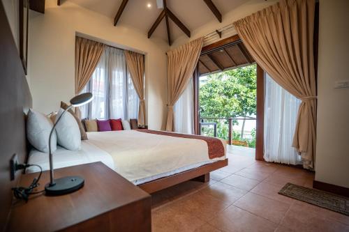 安达Island View Beachfront Resort的一间卧室设有一张床和一个大窗户
