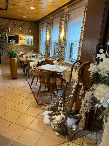 ReuthGasthaus Hubertus的餐厅设有桌椅和窗户。
