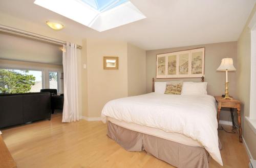 悉尼Heron View Cottage的一间卧室设有一张大床和天窗