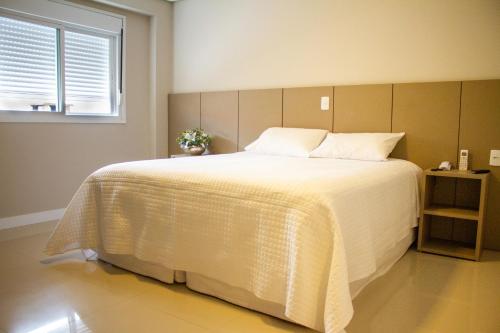Telêmaco BorbaHotel Seville Comfort的卧室配有一张大白色床和窗户