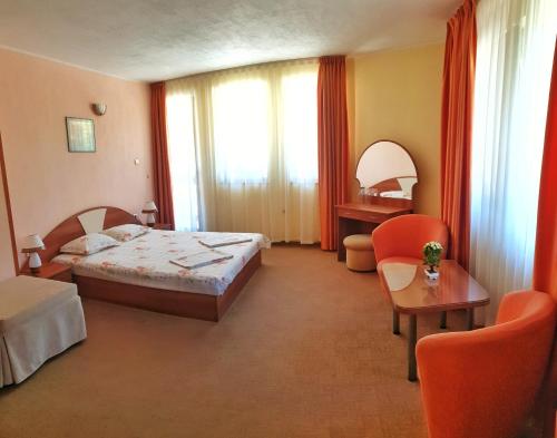 巴奇科伏Семеен Хотел Бачково的酒店客房带一张床、一张桌子和椅子