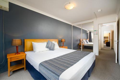 霍恩斯比Hornsby Furnished Apartments的一间卧室设有一张蓝色墙壁的大床