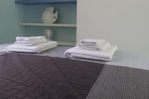切塔拉Casa Azzurra的两堆毛巾坐在房间里地板上