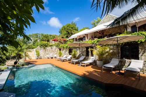 圣马丁岛The Paradise Peak的房屋旁的游泳池配有椅子和遮阳伞