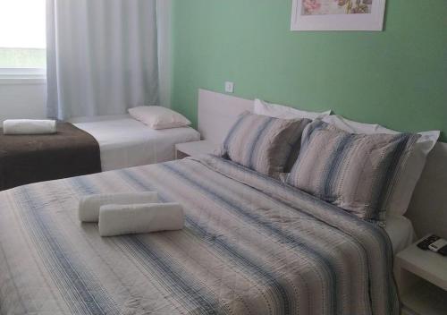 普拉亚多斯卡内罗斯Apart Hotel Praia dos Carneiros Apto 101的一间卧室配有一张带两个枕头的床