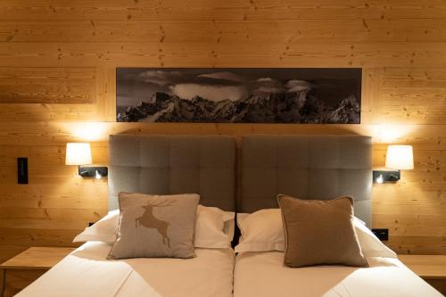 韦尔比耶羚羊酒店的一间卧室配有带白色床单和枕头的床。