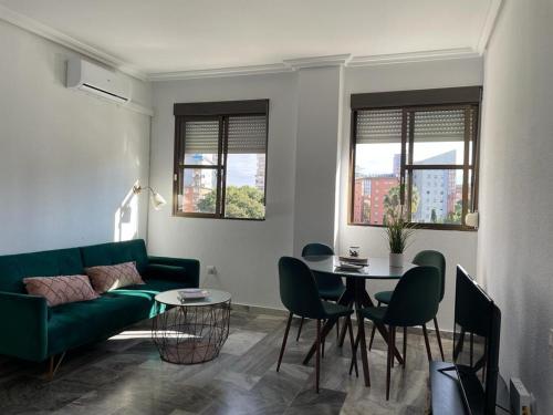 韦尔瓦Apartamento turístico La Joya的客厅配有绿色沙发和桌子