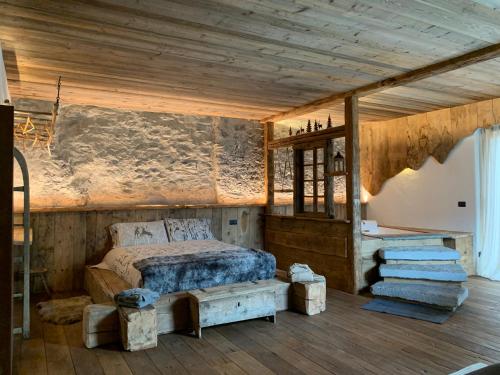 博尔米奥AL BAIT DA LUCIA Bormio的一间卧室设有一张床和木制天花板