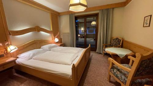 措布伦阿尔潘罗斯酒店的卧室配有床、椅子和窗户。