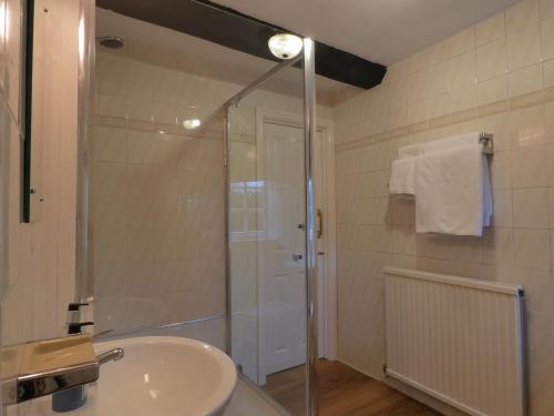 萨顿科尔菲尔德布鲁克马斯顿农场酒店的一间带玻璃淋浴和水槽的浴室