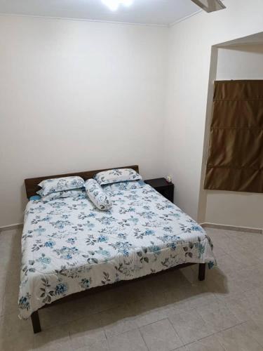 芙蓉NuReezal Homestay Seremban的一间卧室配有一张带蓝色和白色棉被的床