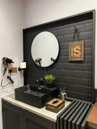 珍南海滩ZUSCH STUDIO的黑色浴室设有水槽和镜子