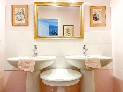 罗斯科夫多曼德普拉特罗住宿加早餐旅馆的浴室设有2个水槽、卫生间和镜子。