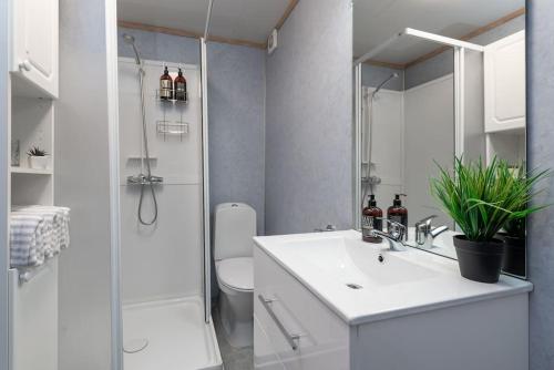 特罗姆瑟Modern apartment in the center of the island的白色的浴室设有水槽和淋浴。