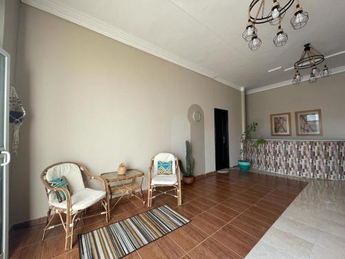 马萨阿拉姆La Casa Guest House的客厅配有两把椅子和一张桌子