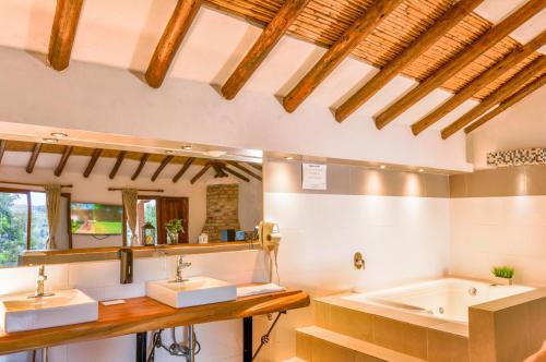 莱瓦镇Casa de Campo Hotel & Spa的浴室配有两个盥洗盆和浴缸。