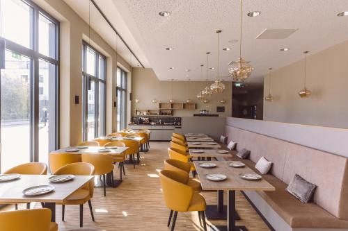 弗莱堡Hotel Libertas elements pure的餐厅设有木桌和黄色椅子