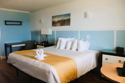 纳格斯黑德Blue Heron Motel的酒店客房,配有一张床铺,上面有毛巾动物